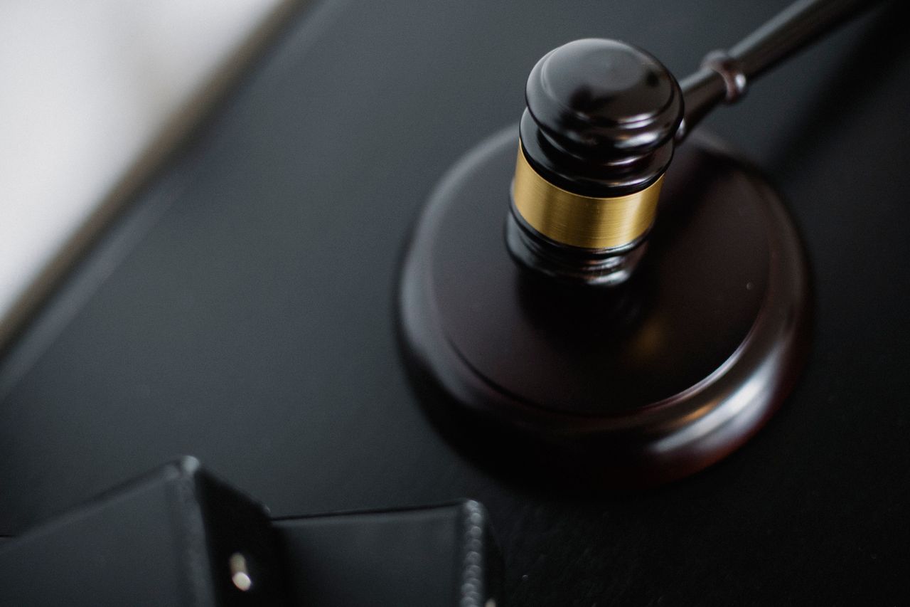 Home From above of wooden gavel on round surface near folders on table in courtroom