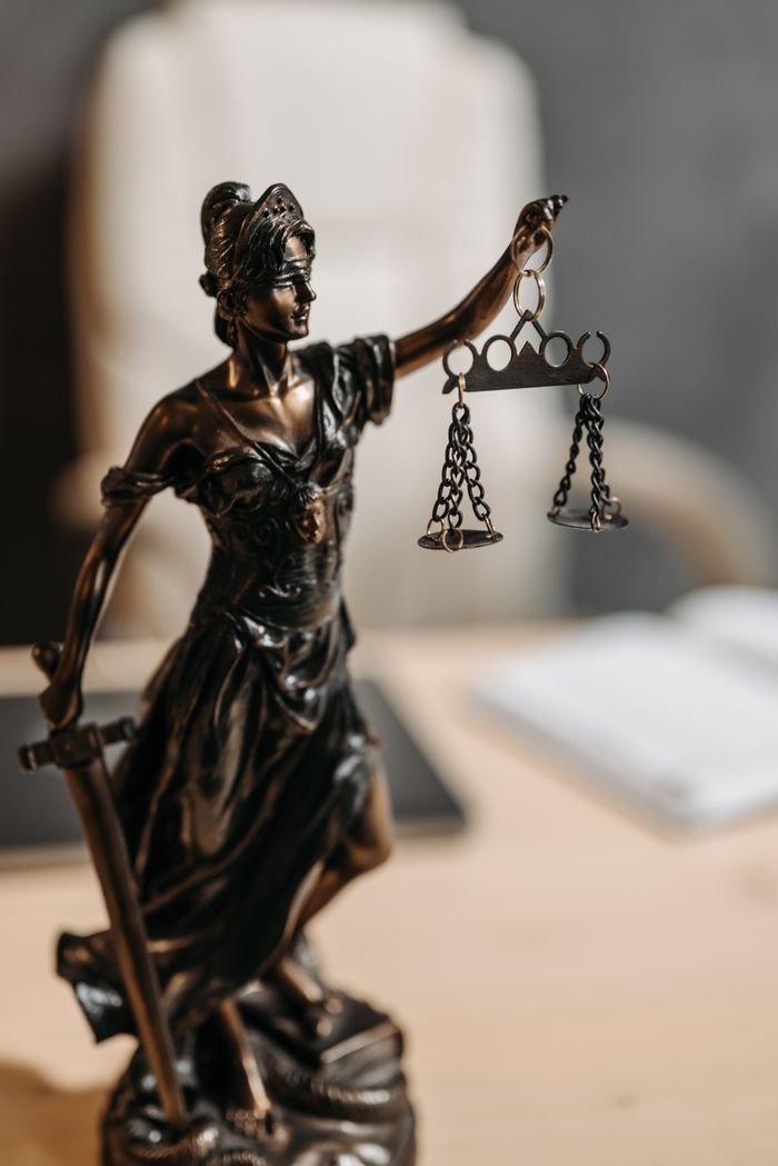Home Bronze Lady Justice statue with scales and sword, symbolizing fairness and law.